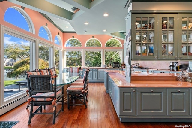 interior space featuring sink, a baseboard radiator, butcher block countertops, crown molding, and hardwood / wood-style flooring