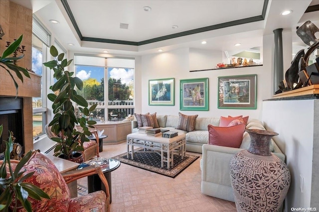 living room with a raised ceiling, ornate columns, and crown molding