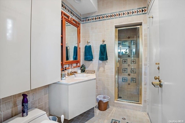 bathroom with tasteful backsplash, walk in shower, vanity, tile walls, and toilet