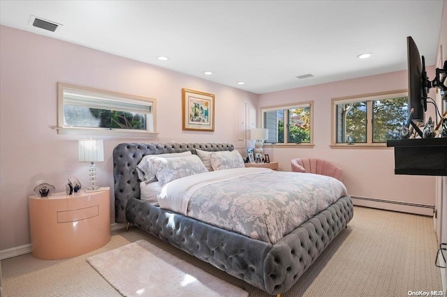 bedroom with baseboard heating and light carpet