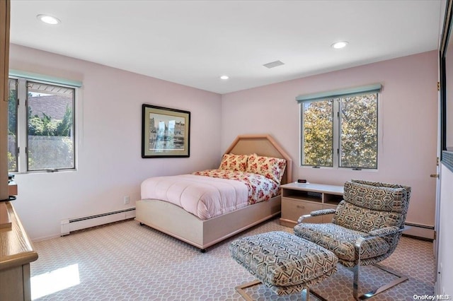 bedroom featuring light carpet and a baseboard heating unit