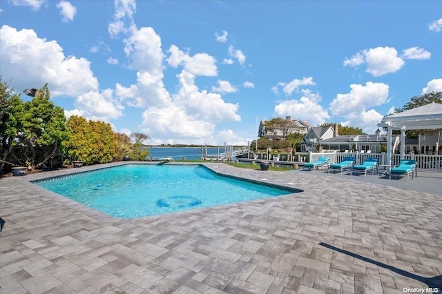 view of swimming pool with a water view and a patio area