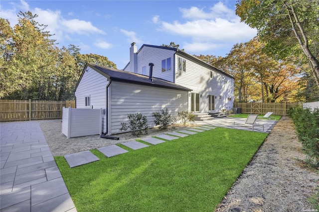 rear view of house featuring a patio and a lawn