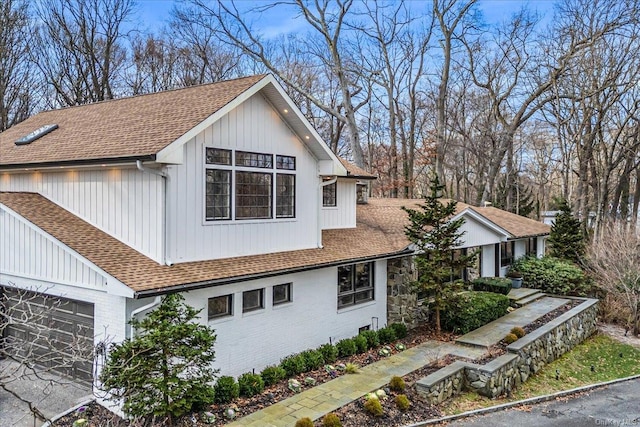 339 Ridge Ln, Mill Neck, NY 11765 - view of home's exterior featuring a shingled roof, a garage, and brick siding