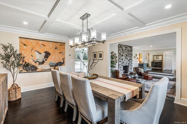 dining room featuring a fireplace, crown molding, dark wood-type flooring, and coffered ceiling