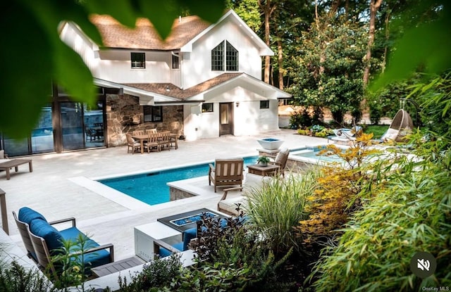 back of house featuring an outdoor fire pit and a patio