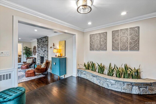 339 Ridge Ln, Mill Neck, NY 11765 - living area with wood finished floors, crown molding, recessed lighting, a stone fireplace, and radiator heating unit