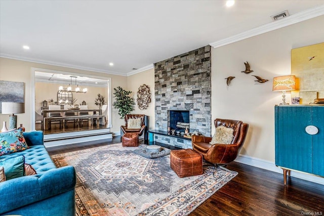 living room featuring hardwood / wood-style flooring, crown molding, a fireplace, and a chandelier