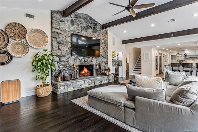 living room featuring vaulted ceiling with beams, ceiling fan, wood-type flooring, and a fireplace