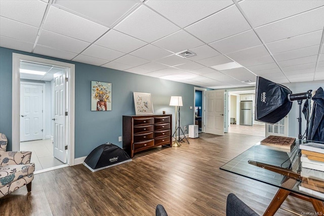 workout area featuring light hardwood / wood-style floors and a drop ceiling