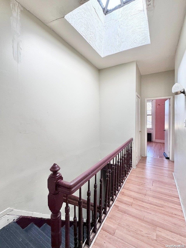 corridor with a skylight and wood-type flooring