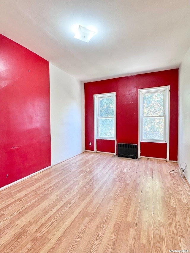 unfurnished room with light hardwood / wood-style floors and radiator