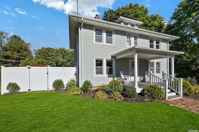 view of front of property featuring covered porch and a front yard