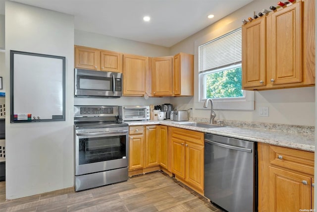 18955 Main Rd, Mattituck, NY 11952 - kitchen with appliances with stainless steel finishes, a sink, recessed lighting, light wood finished floors, and light brown cabinetry