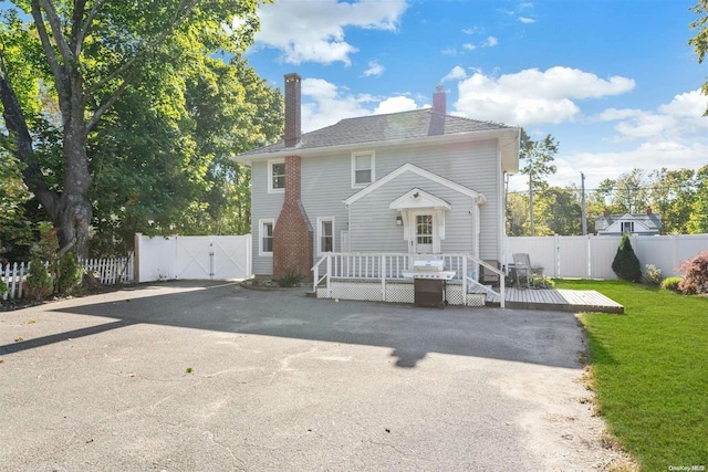 rear view of house featuring a wooden deck