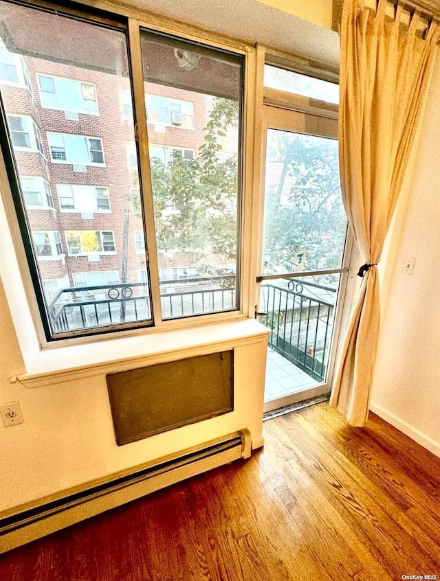 doorway to outside with hardwood / wood-style floors and a baseboard radiator