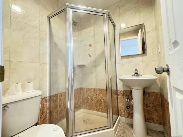 bathroom featuring toilet, an enclosed shower, and tile walls