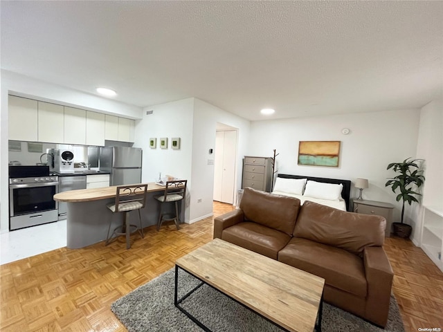 living room featuring sink, light parquet flooring, and a textured ceiling