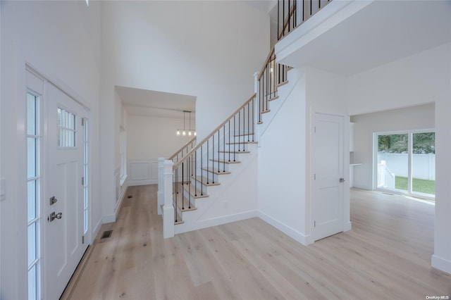 foyer featuring a towering ceiling and light hardwood / wood-style flooring