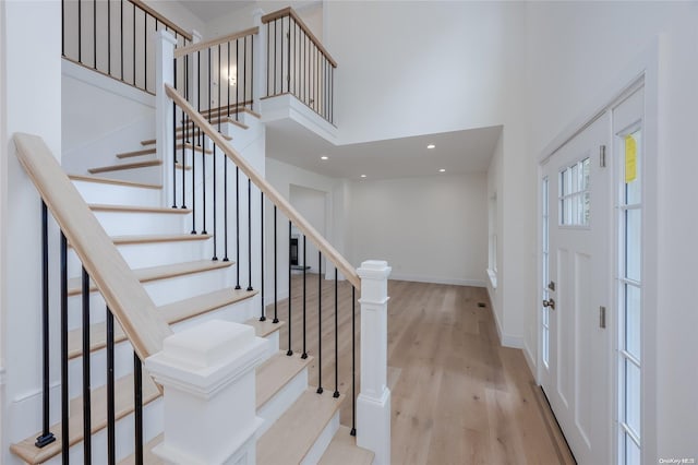 foyer entrance featuring a high ceiling and light hardwood / wood-style flooring