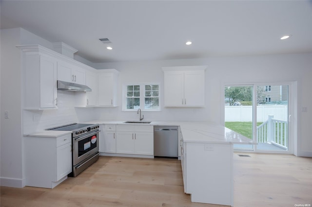 kitchen featuring white cabinets, sink, light hardwood / wood-style flooring, light stone counters, and stainless steel appliances