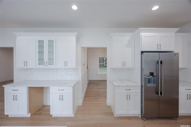 kitchen with white cabinets, stainless steel fridge, and light wood-type flooring