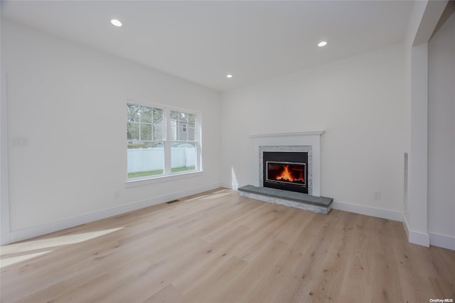 unfurnished living room with a fireplace and light hardwood / wood-style flooring