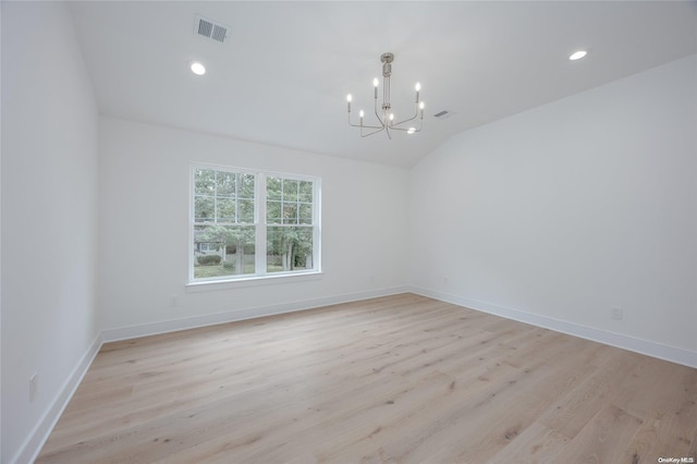 unfurnished room with light hardwood / wood-style floors, lofted ceiling, and an inviting chandelier