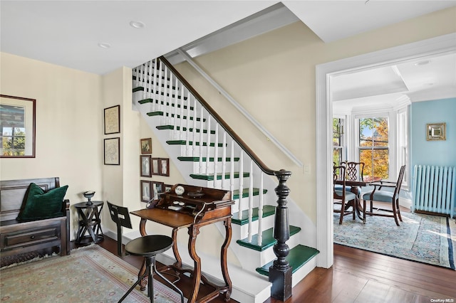 stairs featuring radiator heating unit and wood-type flooring