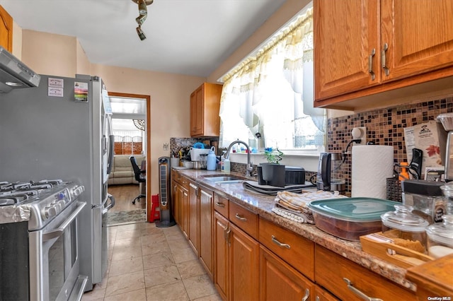 kitchen featuring sink, light stone countertops, range hood, tasteful backsplash, and gas stove