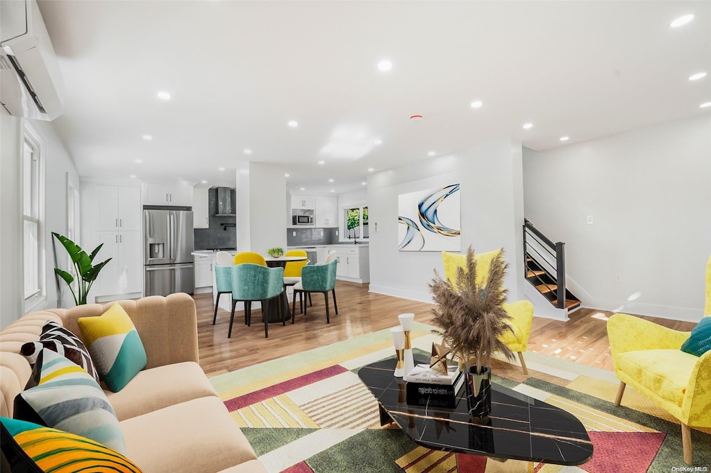 living room featuring light hardwood / wood-style floors and a wall mounted AC