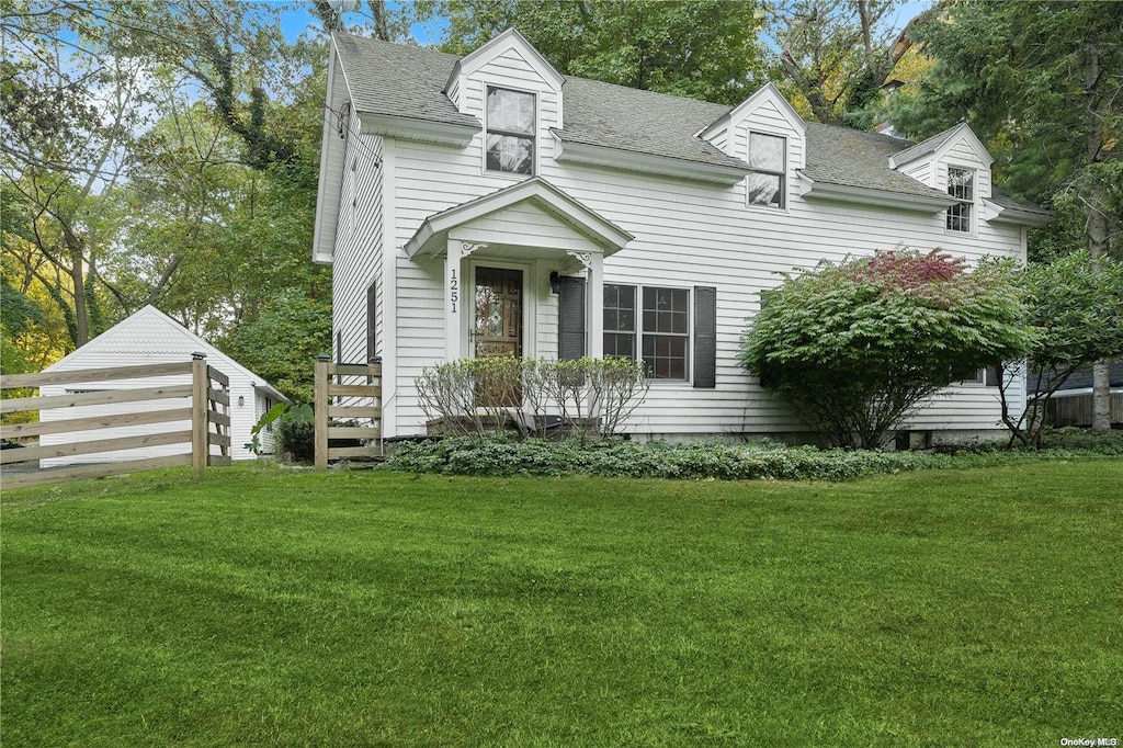 cape cod home featuring a front lawn