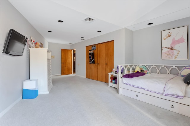 bedroom with light carpet, vaulted ceiling, and a closet