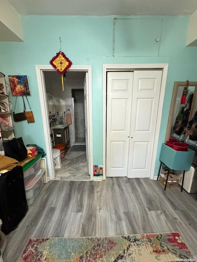 bedroom featuring connected bathroom, a closet, and wood-type flooring