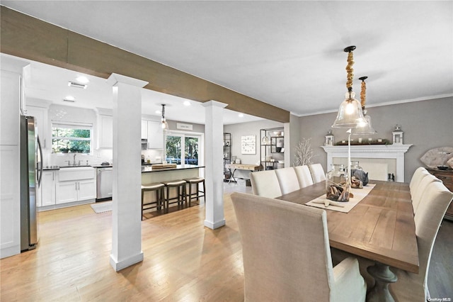 dining room featuring light hardwood / wood-style floors, ornamental molding, and sink