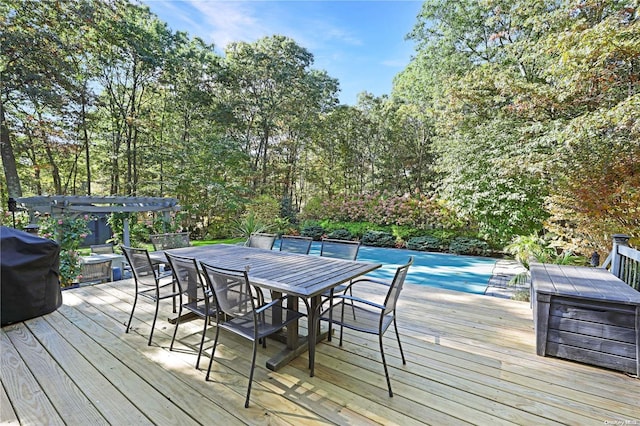 wooden deck with grilling area and a covered pool