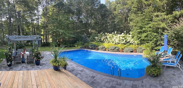 view of swimming pool featuring a deck and a pergola