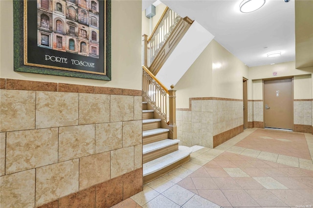 staircase with tile patterned flooring and tile walls