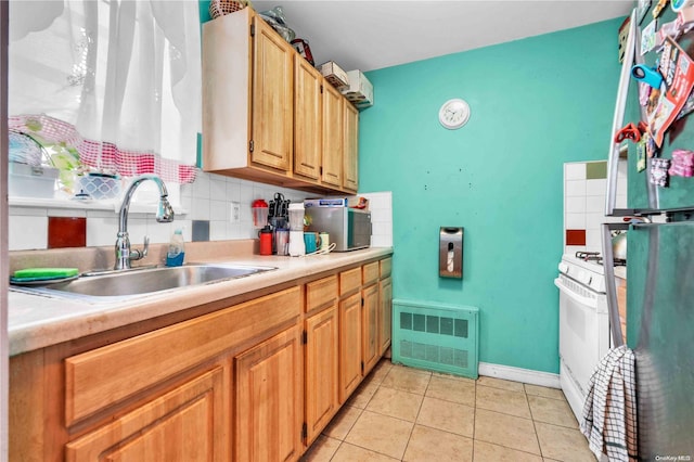 kitchen featuring decorative backsplash, white range, light tile patterned floors, and sink