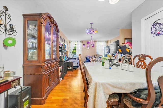 dining room featuring light hardwood / wood-style flooring and a notable chandelier