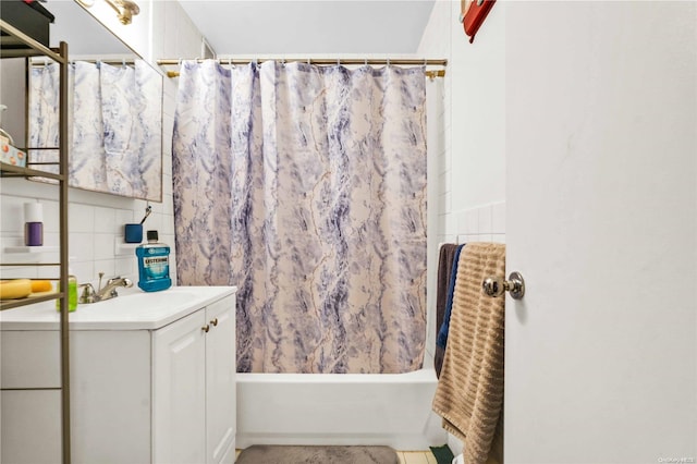 bathroom with vanity, shower / bathtub combination with curtain, and tile walls