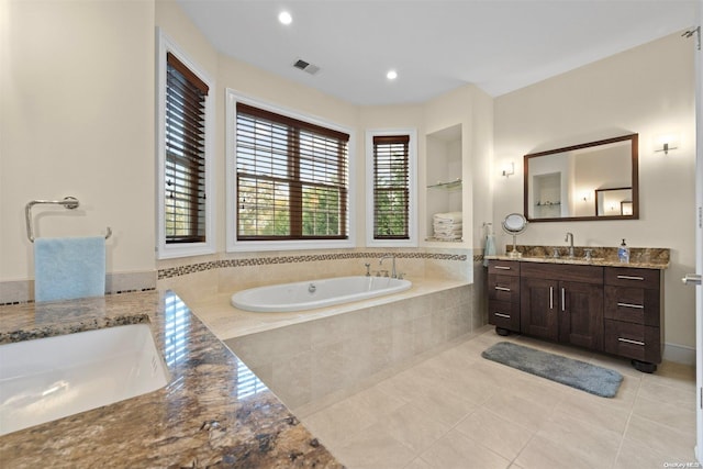 bathroom with a relaxing tiled tub, tile patterned floors, and vanity