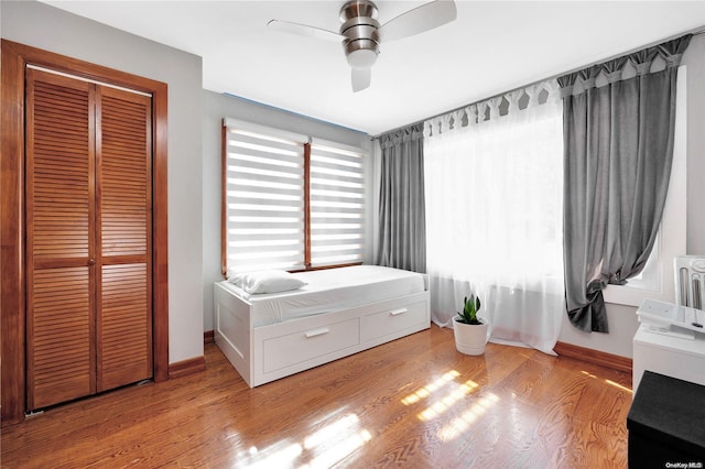 bedroom with ceiling fan, light wood-type flooring, and a closet