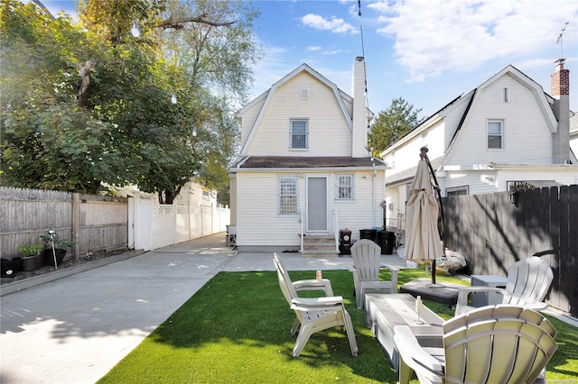 rear view of property featuring a lawn and a patio area