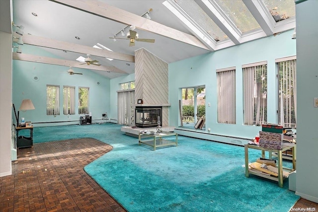 view of swimming pool with a skylight, ceiling fan, and a fireplace