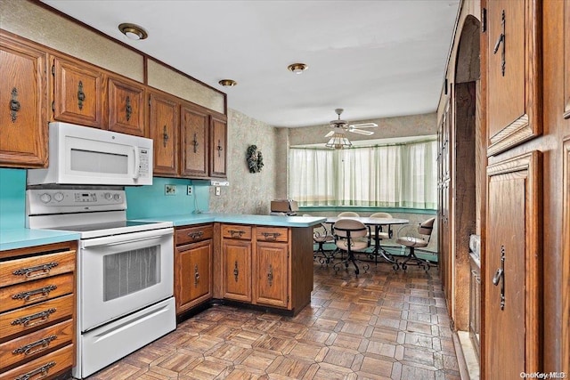 kitchen with kitchen peninsula, ceiling fan, and white appliances