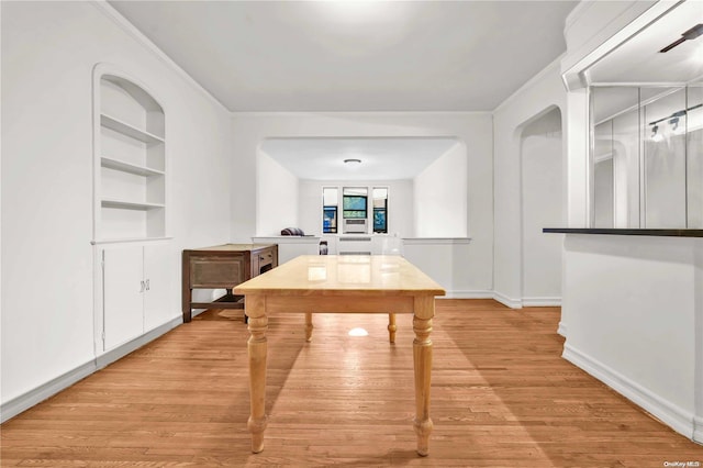 interior space featuring ornamental molding, light hardwood / wood-style floors, and built in features