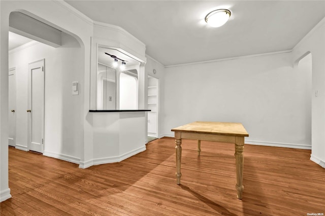 interior space featuring ornamental molding, hardwood / wood-style floors, and built in features