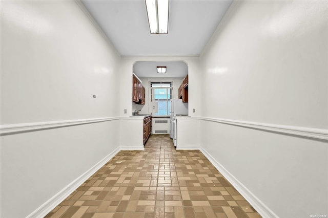 corridor with sink and crown molding