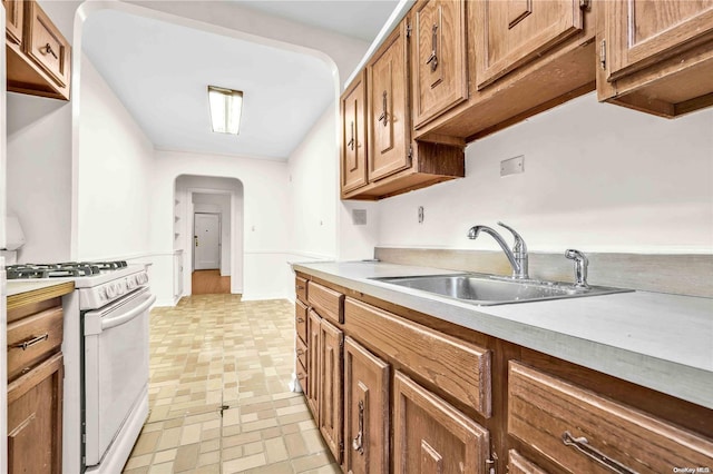 kitchen featuring sink and white range with gas stovetop